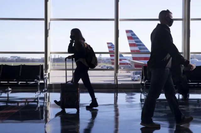 Travellers walk through a terminal at Ronald Reagan Washington National Airport in Arlington, 24 November 2020