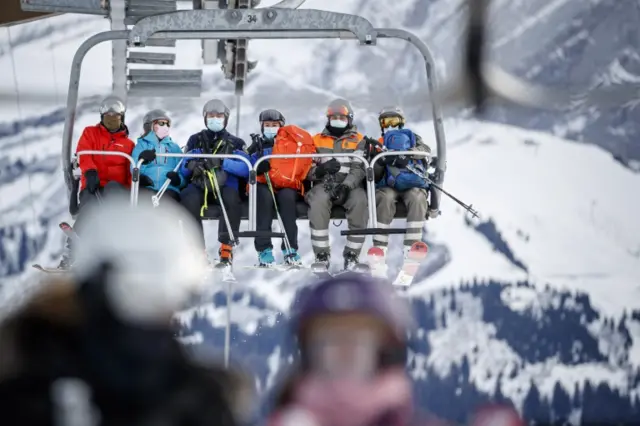 A policewoman and policeman (center) ride a ski lift as they patrol on the slopes in Switzerland, 19 December