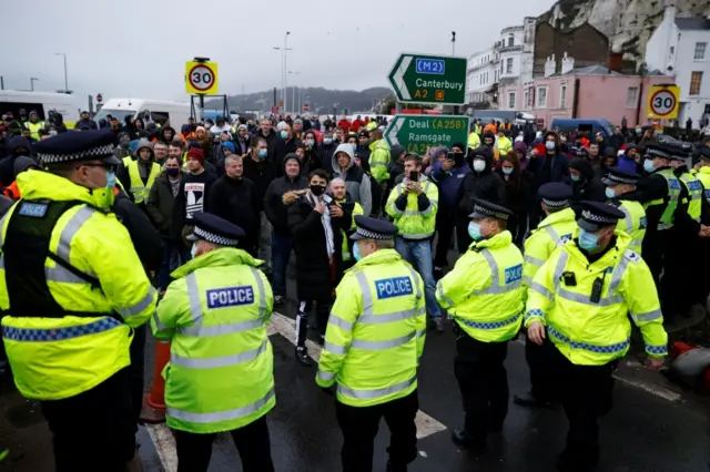 Drivers stand in front of police officers as they block the exit at the Port of Dover