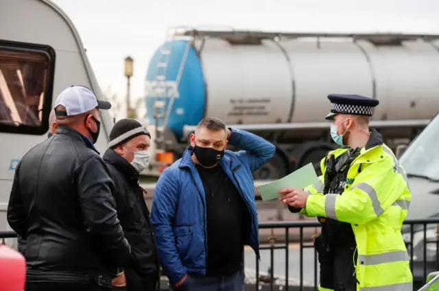 A police officer speaks with hauliers near the Port of Dover as he directs them to parking at Manston Airport