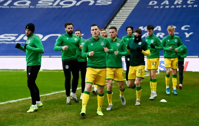 Hibs players warming up at Ibrox