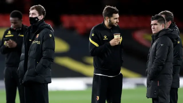 Watford players assess the pitch