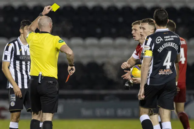 Lewis Ferguson (partially hidden) receives his second yellow card of the game