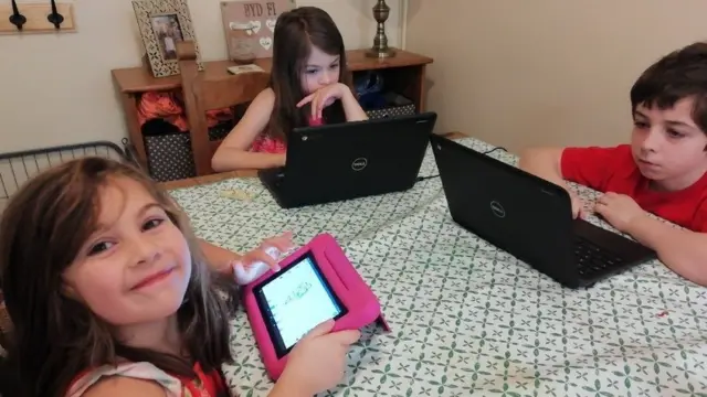 Self-isolating children working at the kitchen table