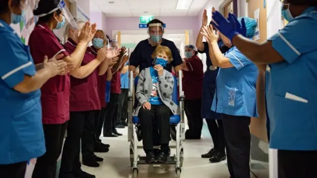 Margaret is applauded by staff as she returns to her ward