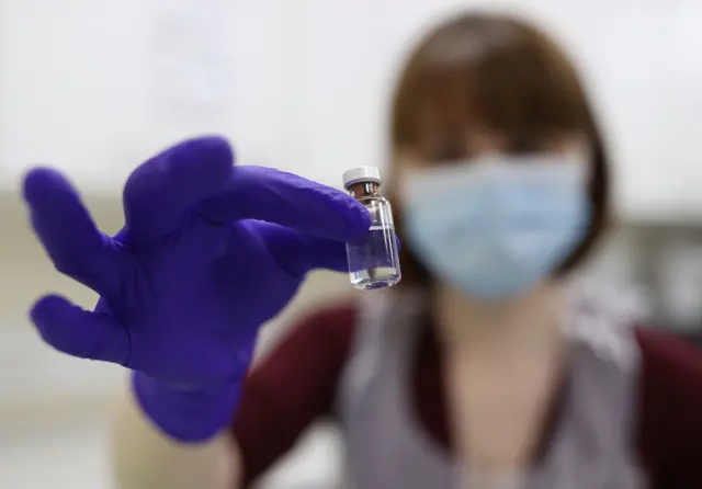 An NHS pharmacy technician at the Royal Free Hospital, London, simulates the preparation of the Pfizer vaccine to support staff training ahead of the rollout.