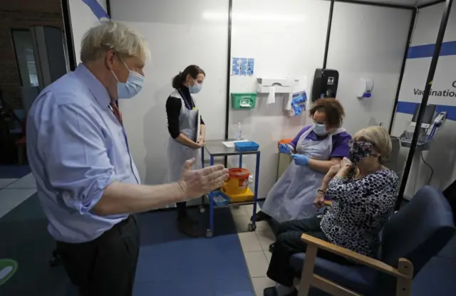 Prime Minister Boris Johnson speaks to nurse Rebecca Cathersides (second right) and Lyn Wheeler (right) before she receives the Pfizer/BioNTech Covid-19 vaccine at Guy's Hospital in London