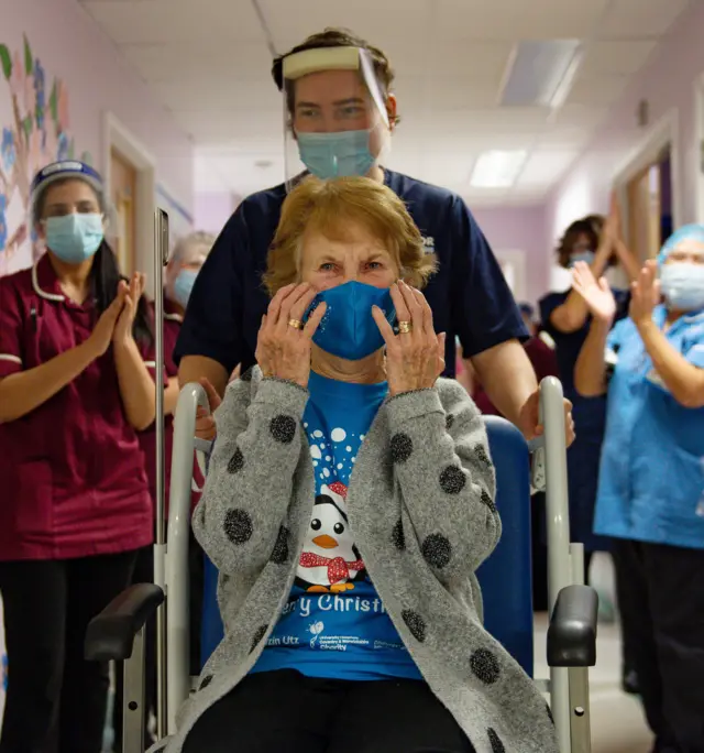 Margaret Keenan, 90, is applauded by staff as she returns to her ward after becoming the first person in the United Kingdom to receive the Pfizer/BioNtech covid-19 vaccine at University Hospital, Coventry