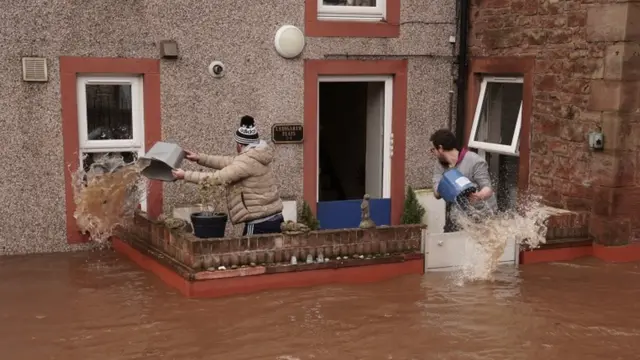 Residents of Appleby-in-Westmorland in Cumbria take water out of a house