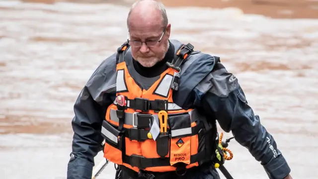 A man walks through floodwater in York after the River Ouse burst its banks.