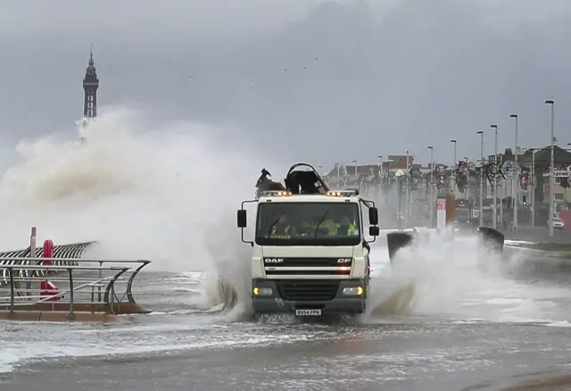 A lorry drives through seawater on the front at Blackpool.