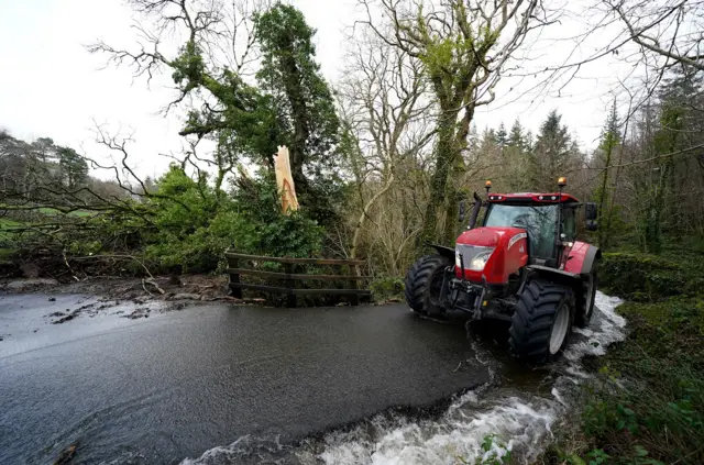 A tractor waits to clear debris on a road near Llanrwst in North Wales