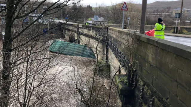 A shipping container under a bridge