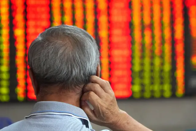 Man watches Asian markets boards.