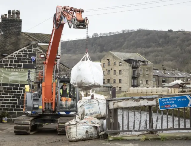 Workers construct flood defences in Mytholmroyd