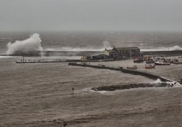 Waves break over wall