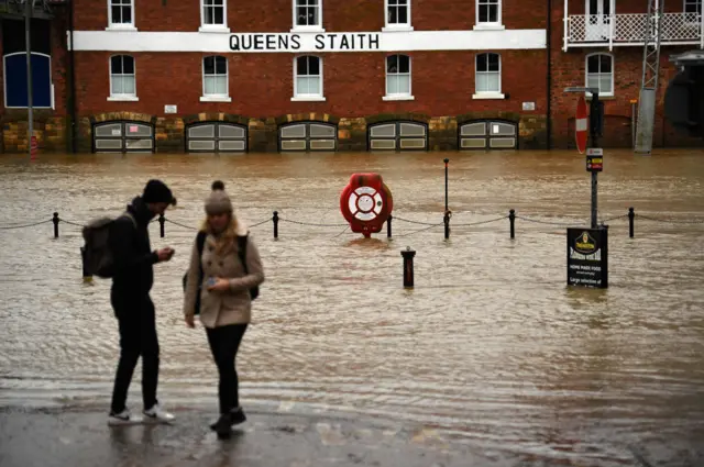 people next to flooded river