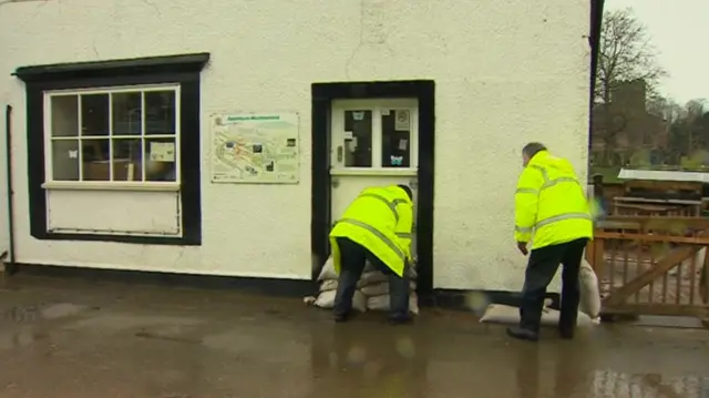 Men put sandbags outside house