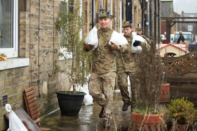 Soldiers carry sandbags to help for flood defences in West Yorkshire.