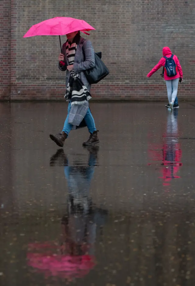 Woman walks through puddles