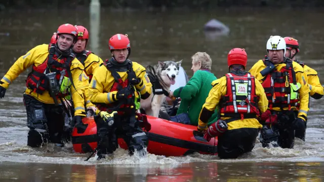 An elderly resident and their dog is pulled to safety on a rescue boat in south Wales.