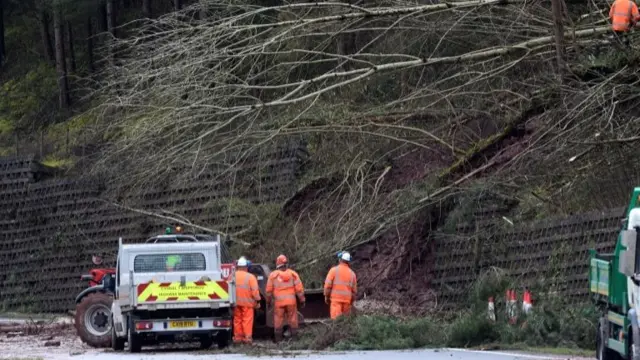 Highway maintenance staff clear a landslide blocking the A40 Brecon bypass