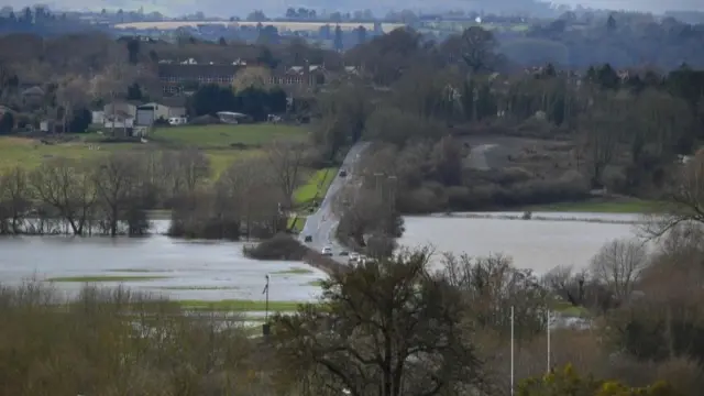 A main road cuts through flooded countryside near Hereford