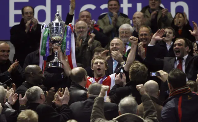 Sean Long celebrates by hoisting the World Club Challenge trophy aloft