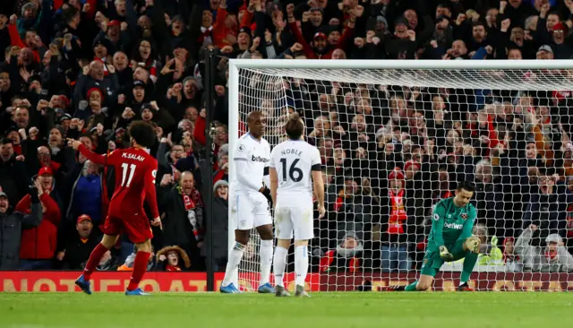 Liverpool's Mohamed Salah celebrates scoring their second goal as West Ham United's Lukasz Fabianski looks dejected