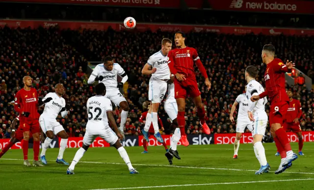 Liverpool's Virgil van Dijk heads at goal