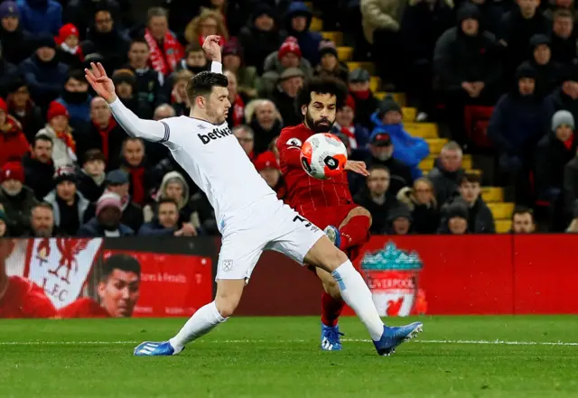 Liverpool's Mohamed Salah shoots at goal as West Ham United's Aaron Cresswell attempts to block