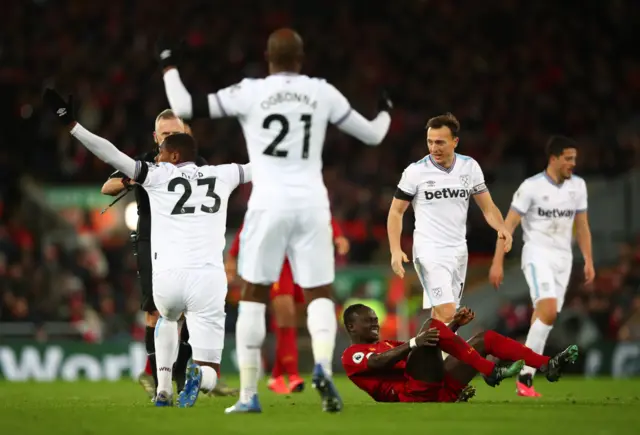 West Ham's Issa Diop is booked after fouling Liverpool's Sadio Mane