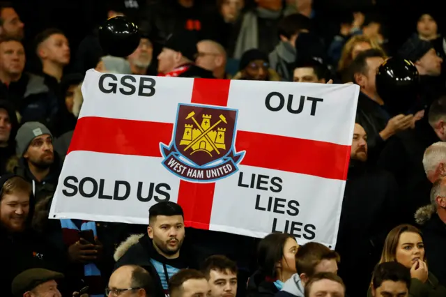 West Ham fans hold up a banner at Anfield