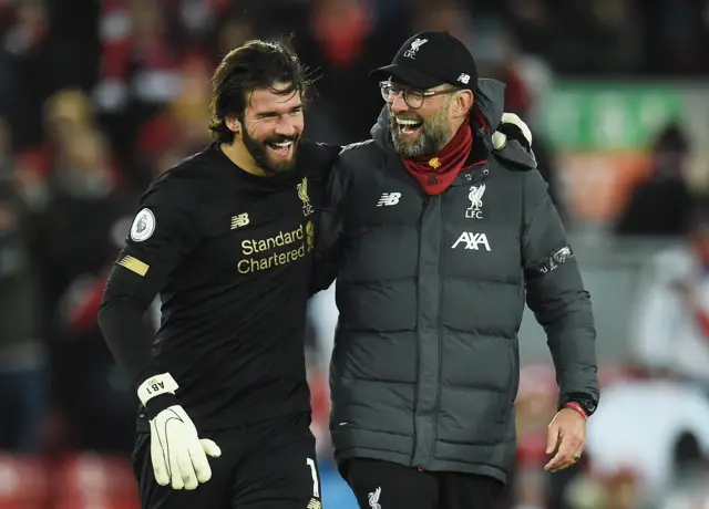 Liverpool manager Juergen Klopp (R) and Liverpool goalkeeper Alisson Becker share a smile after the English Premier League match between Liverpool and West Ham