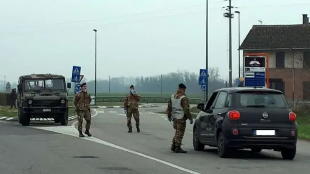 Italian soldiers set up a checkpoint near Lodi, northern Italy, 25 February 2020.