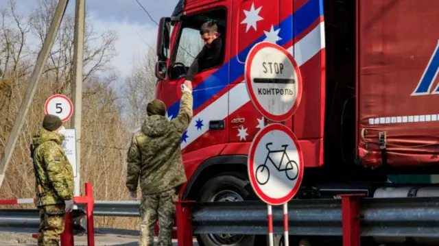 Ukrainian immigration officers check the body temperature of a lorry driver at the border checkpoint near the town of Chop, Ukraine, 25 February 2020.