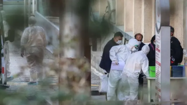 Health personnel wearing protective gear help passengers and crew of a Turkish Airlines plane from Tehran being taken to Dr. Zekai Tahir Burak Hospital for a 14-day quarantine and to be tested for possible coronavirus infection on February 25, 2020 in Ankara, Turkey.