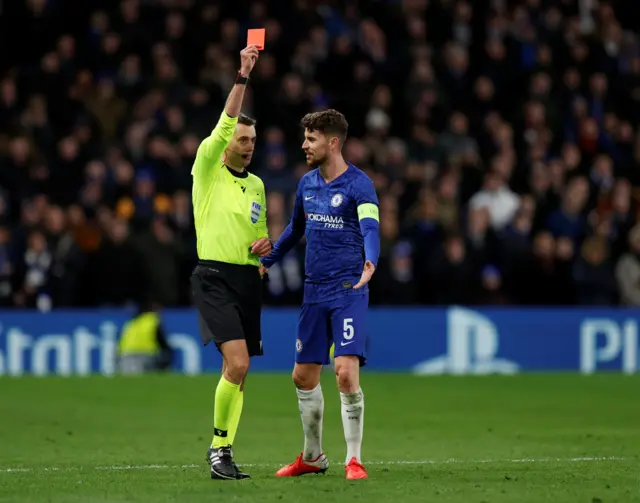 Referee Clement Turpin shows a red card to Chelsea's Marcos Alonso (not pictured) as Chelsea's Jorginho appeals