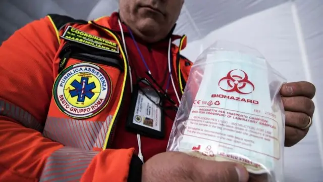 Italian emergency worker with a biohazard bag