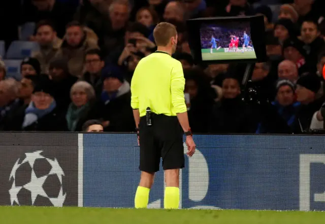 Referee Clement Turpin checks a VAR screen on the side of the pitch before showing a red card to Chelsea's Marcos Alonso