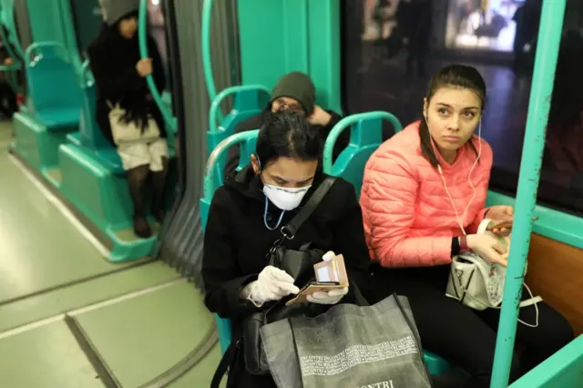 A passenger of the public transport wears a protective mask and gloves on February 26, 2020 in Milan, Italy.