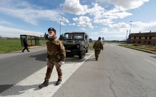 Italian soldiers guard the entrance of the red zone of Turano Lodigiano