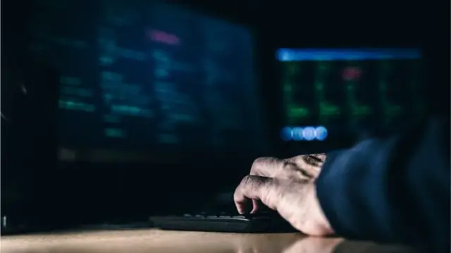 A man typing on a computer keyboard