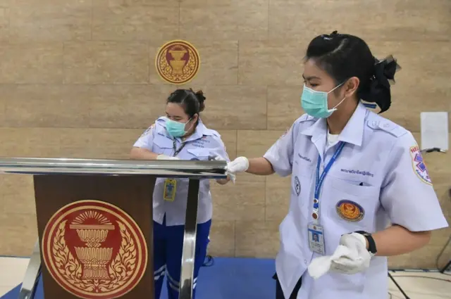 Cleaners disinfect the Thai parliament in Bangkok - after a lawmaker had been in the building following a trip to Japan.