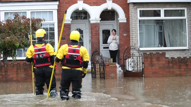 Firefighters help a woman