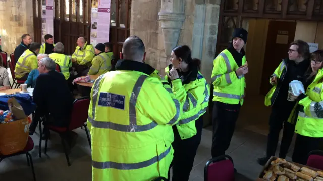 People in high vis vests inside a church