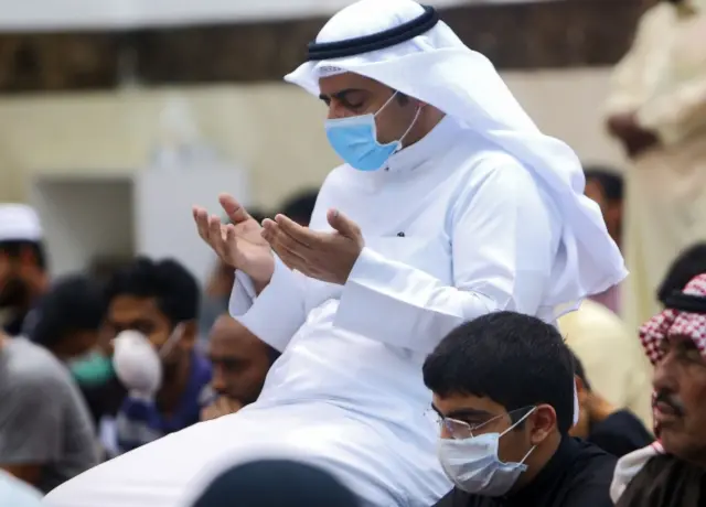 A man prays with a face mask in Kuwait