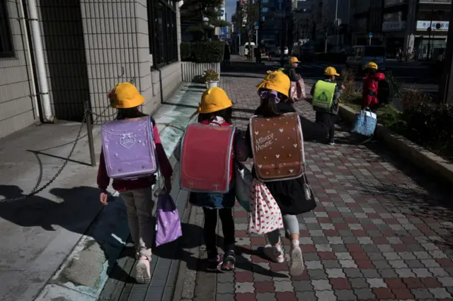 Elementary school students make their way home on February 27, 2020 in Ichikawa, Japan.