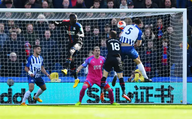 Lewis Dunk heads at goal