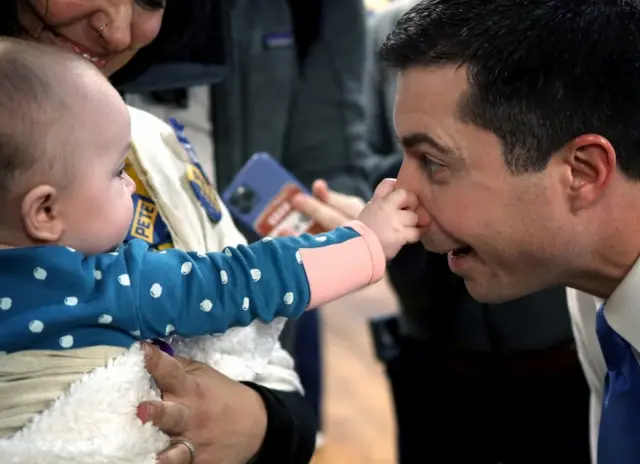 Seven month old Emerson Hansen grabs the nose of Democratic presidential candidate former South Bend, Indiana Mayor Pete Buttigieg